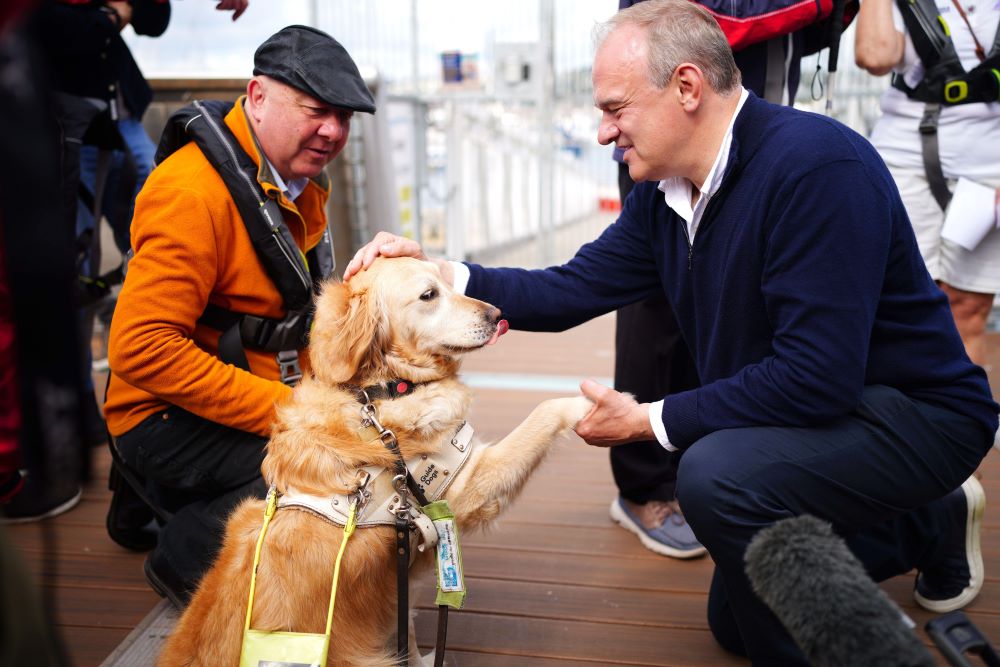 Liberal Democrats leader Sir Ed Davey pets Jennie, the Guide Dog belonging to parliamentary candidate for Torbay, Steve Darling